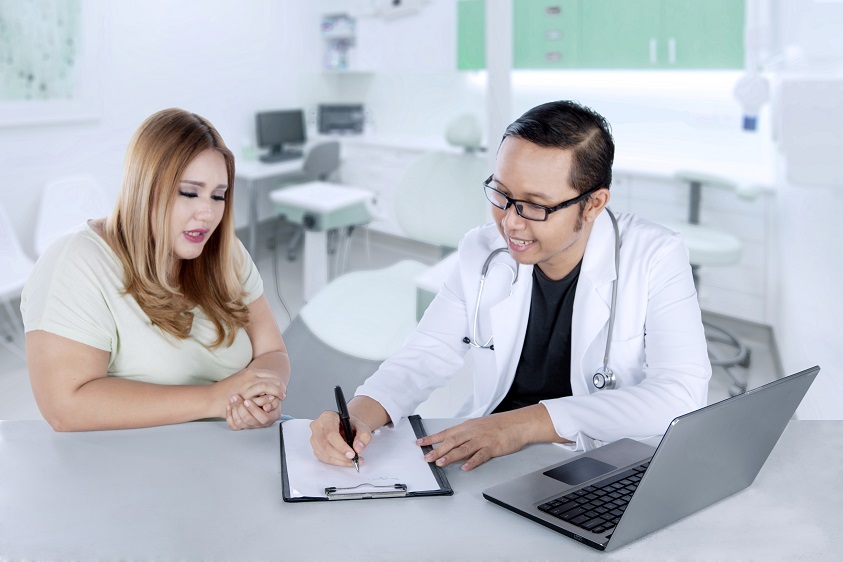Doctor talking to patient and writing down notes