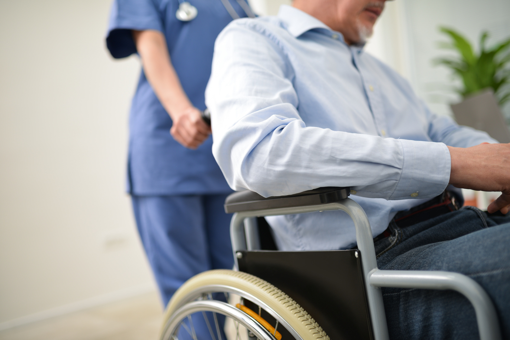Nurse pushing man in wheelchair